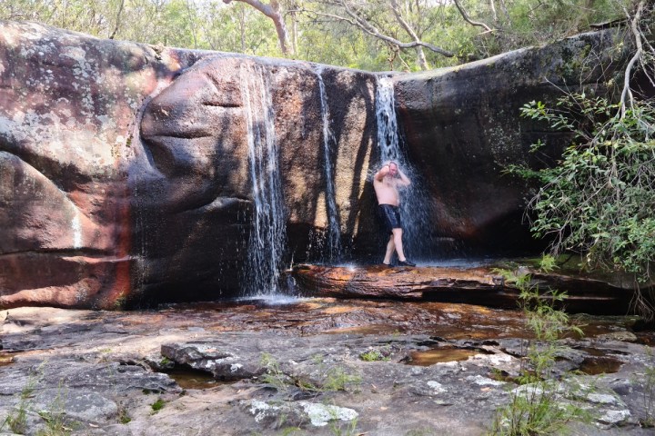 a person standing next to a waterfall