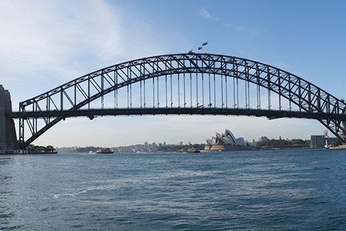 a train crossing Sydney Harbour Bridge over a body of water