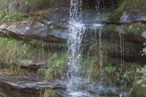 a waterfall going over a body of water
