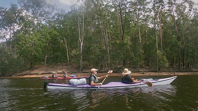 a group of people riding on the back of a boat in the water