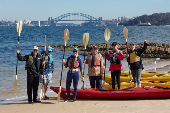 a group of people standing next to a body of water