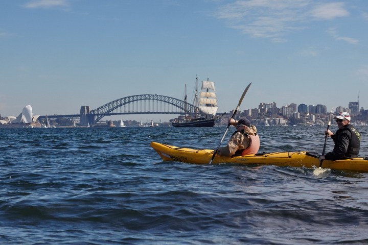 a man riding on the back of a boat in the water