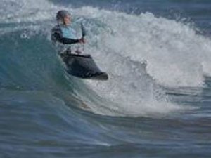 about-image-02 a man riding a wave on a surfboard in the ocean