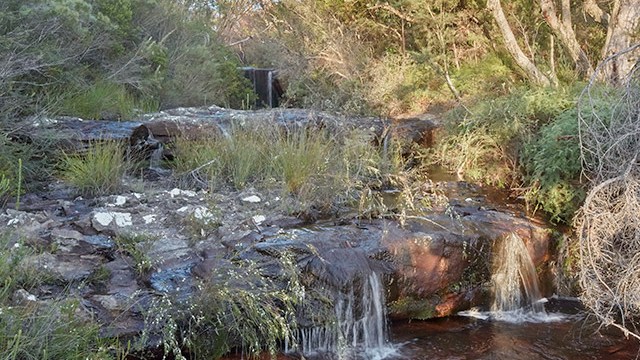 a large waterfall next to a river